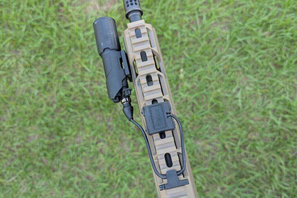 Rifle with offset light and pressure switch routed along handguard