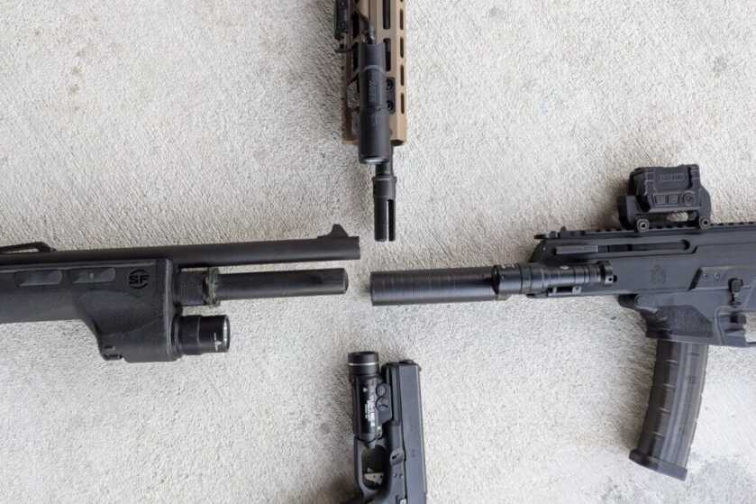 Four firearms each equipped with weapon-mounted lights for comparison