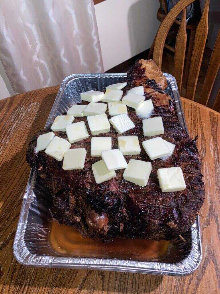 Elk rear quarter in pan with apple juice and butter cubes before foil wrap