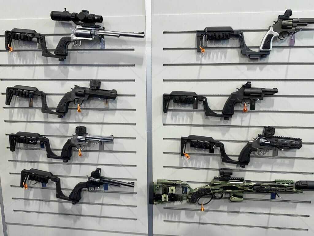 A wall is covered with pistols hanging on hooks. Each has the attachable Bounty Hunter Series stock or brace.