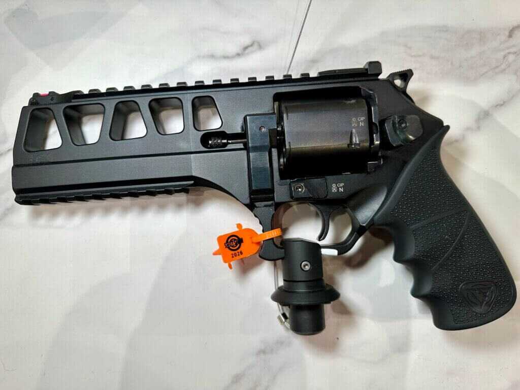 Left side of the Chiappa revolver on display. The black gun is laying on a white granite countertop.