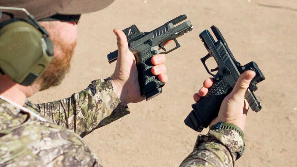 Close up of left- and right-handed pistols in a shooter's hands at the range.
