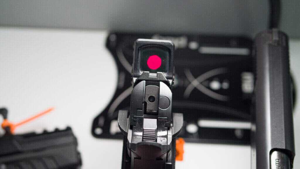 Looking at the back of the gun with the red dot illuminated in the optic.