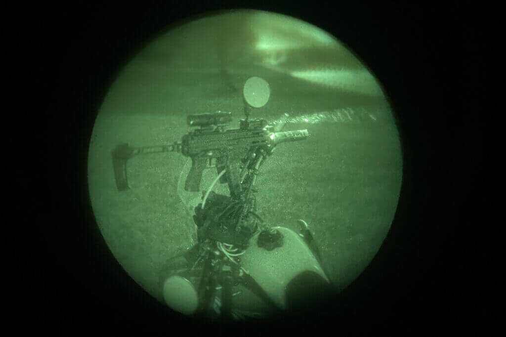 Holosun IRIS-3 mounted on a rifle outdoors showing compact low-profile laser and illuminator setup