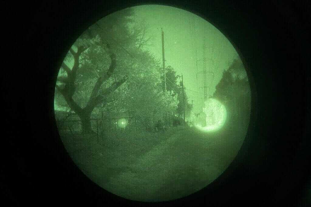 Holosun IRIS-3 aiming laser visible in an urban night environment with ambient light