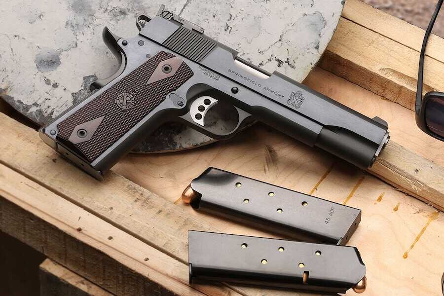 The 1911 Garrison Target pistol on a wooden bench.