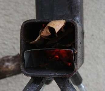 Leaves are easy to smother your fire, but if you are careful, thick leaves like these Mango leaves actually have a decent amount of BTUs in them.  You can put them in the top too. 