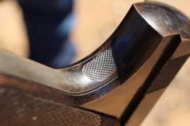 Checkering on the mainspring housing. The shape of the checkering changed when the Woodsman was updated to shoot High Velocity ammo. 