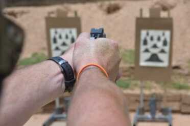 Two-handed shooting. Note how the cocked hammer rests in the web of the hand without pinching.
