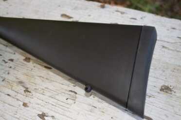 The stock has a fixed sling attachment point and a soft rubber recoil pad. 