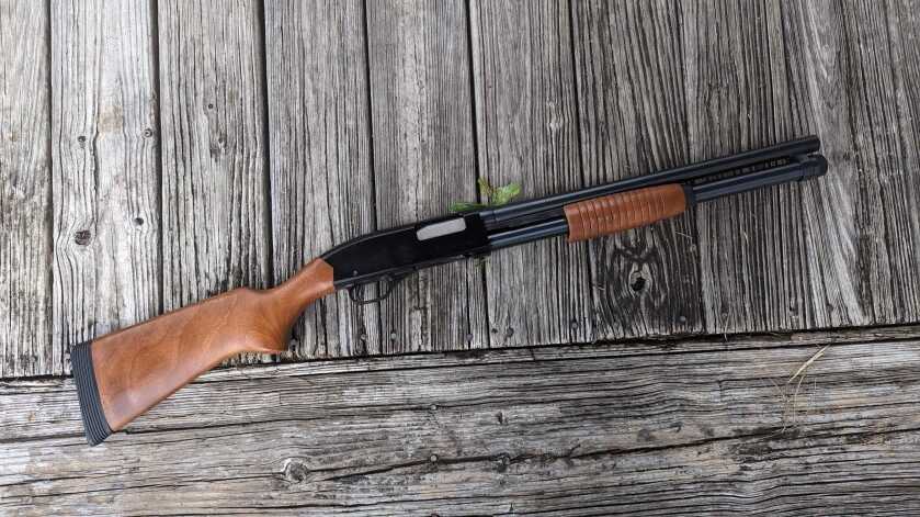 Winchester 1300 Defender shotgun against aged wood 