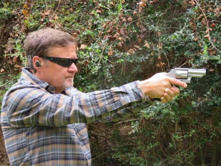 Shooter with glasses and hearing protection shooting the Smith and Wesson Model 66