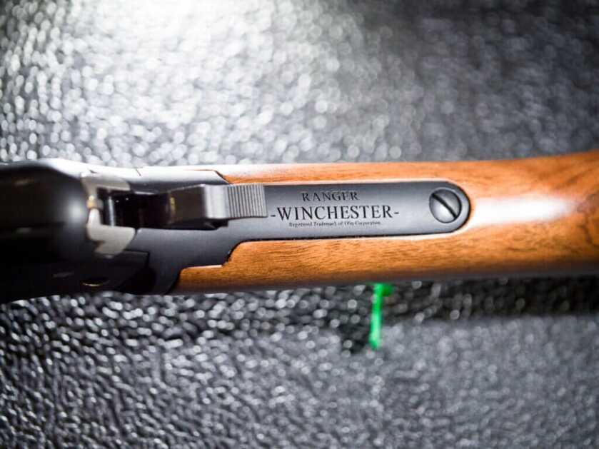 Closeup view of the tang with brand engraving. the gun is pointed left.