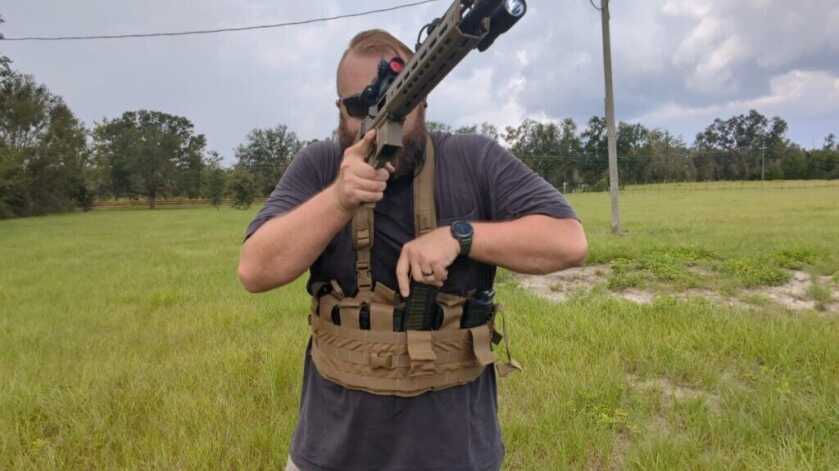 shooter actively drawing magazine from chest rig