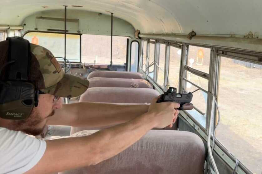 Aiming gun through window of old bus
