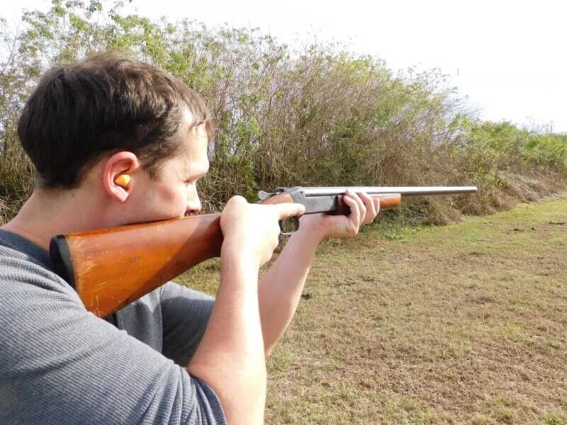 the author aims a shotgun; squirrel hunting guns