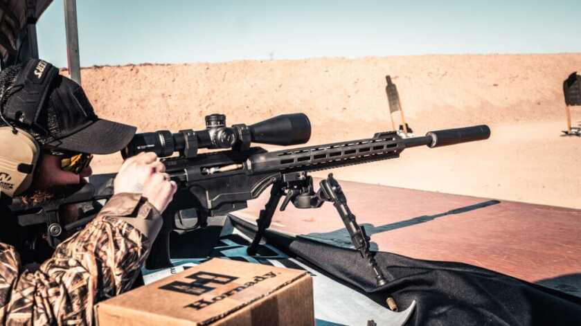 A shooter operates a bolt action rifle at the gun range.
