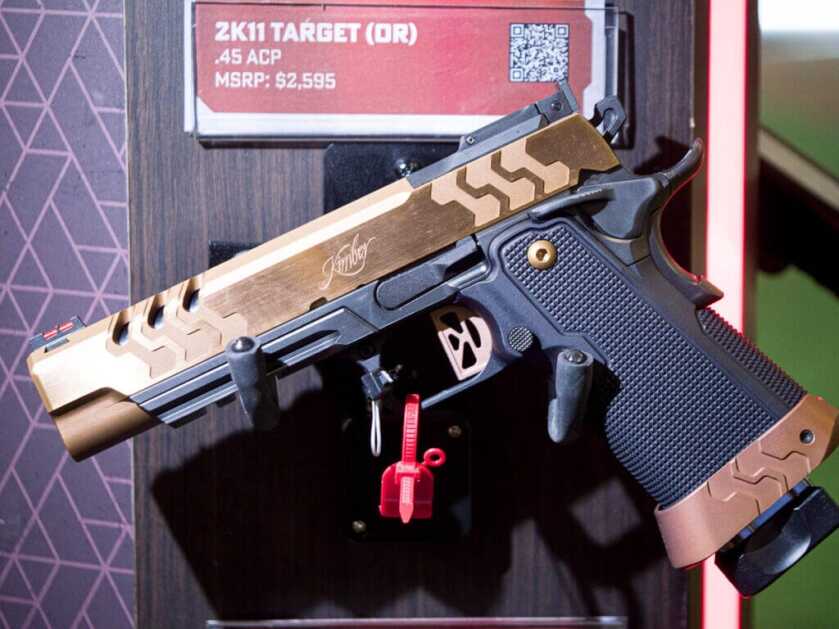 A golden gun sits on a wall mounted rack and points to the left. 