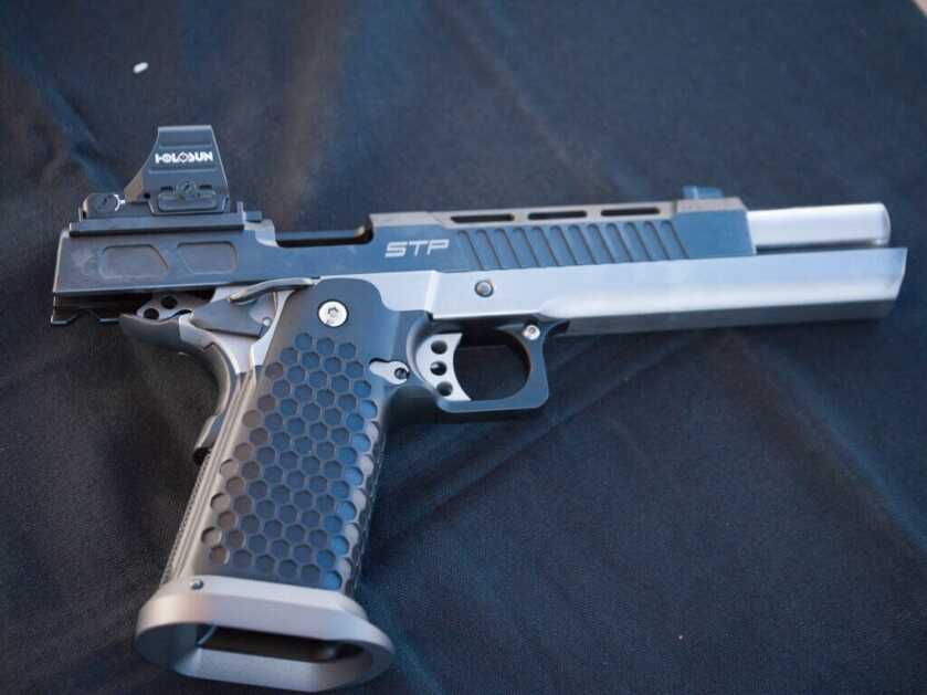 A handgun is staged on a black backdrop, pointing to the right.