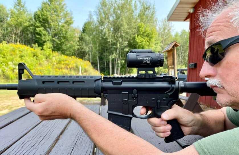 3 - Big Features, Small Scope: The P8 4x Prismatic Optic Man in sunglasses shooting an AR-15 with the Lucid Optics P8 4x