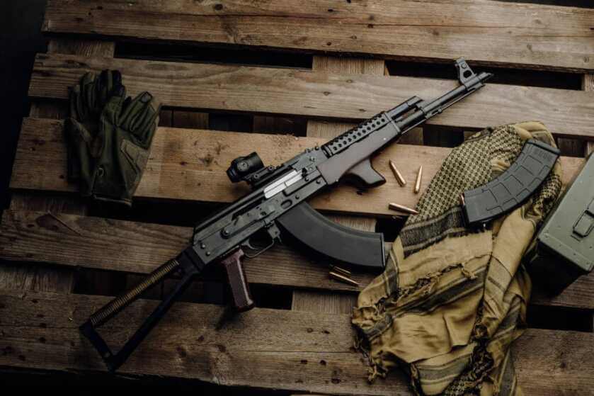 AK Buyers Guide AK Rogow Jack Rifle on wooden platform with magazines, ammunition, and gear bag