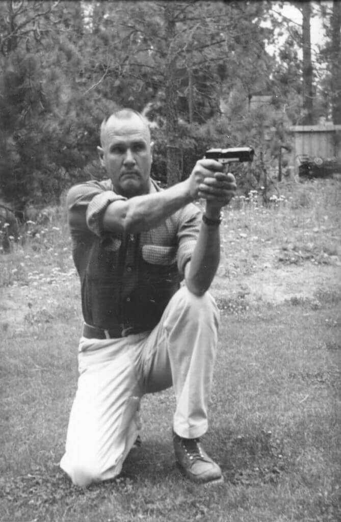 black and white photo of a man shooting pistol jeff cooper four safety rules