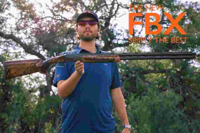 A shooter holding up a Blaser FBX competition shotgun.