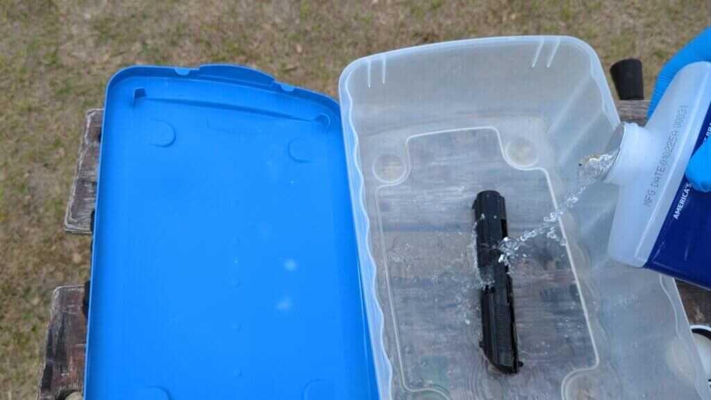 mineral spirits pouring into container with gun part