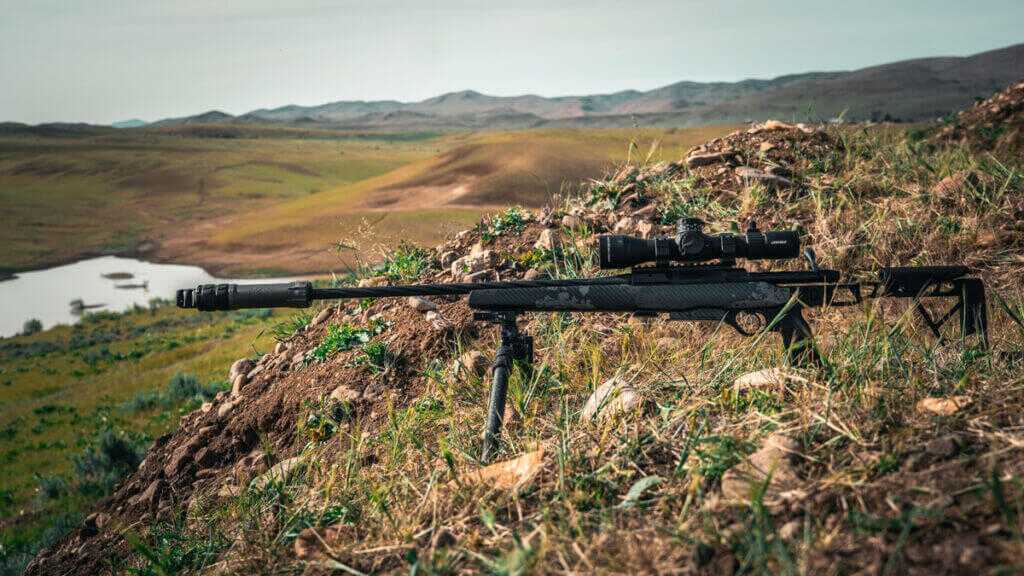 rifle with a bipod on a hillside