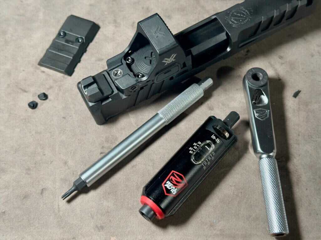 The wrench and adjustable torque limiter lay next to a pistol slide with a freshly-installed optic. 