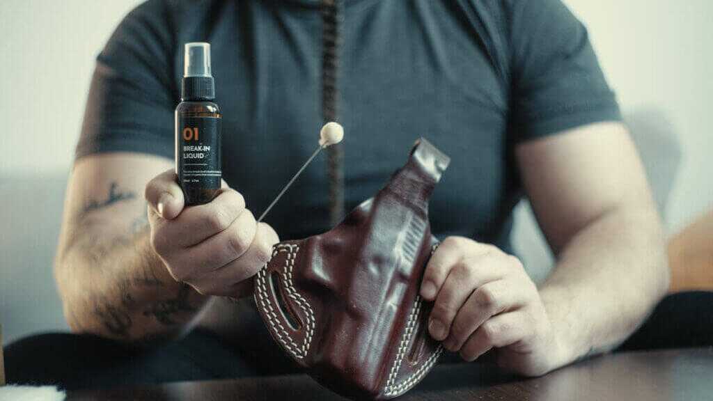 Applying denatured alcohol to a leather holster for proper break-in.