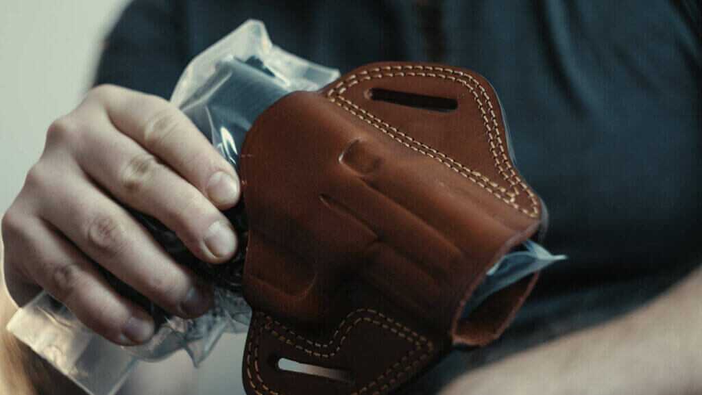 Pistol placed in plastic bag for breaking in a leather holster.