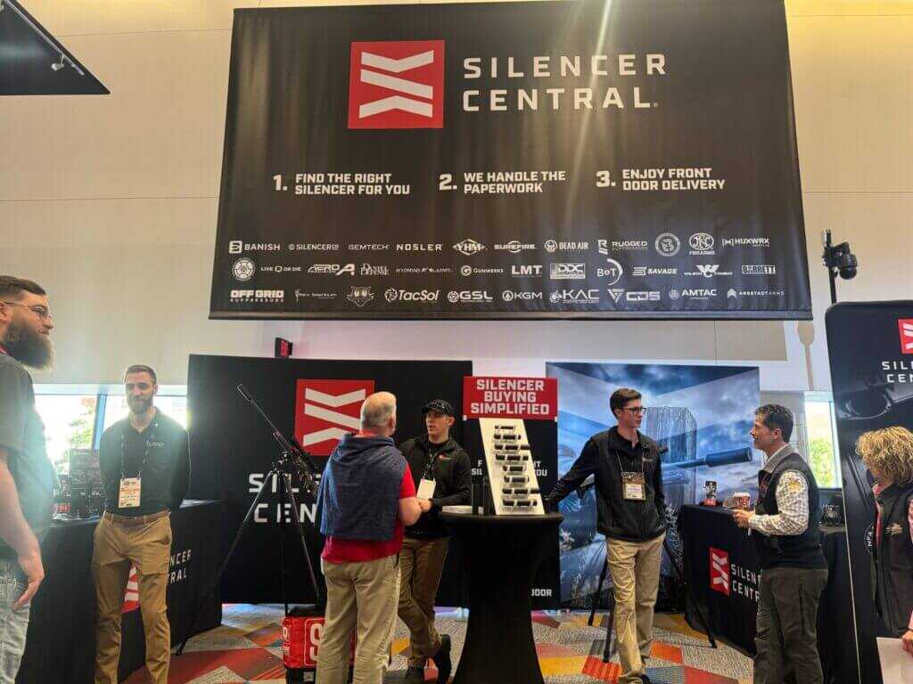 Silencer Central booth at a gun show with customers and signage