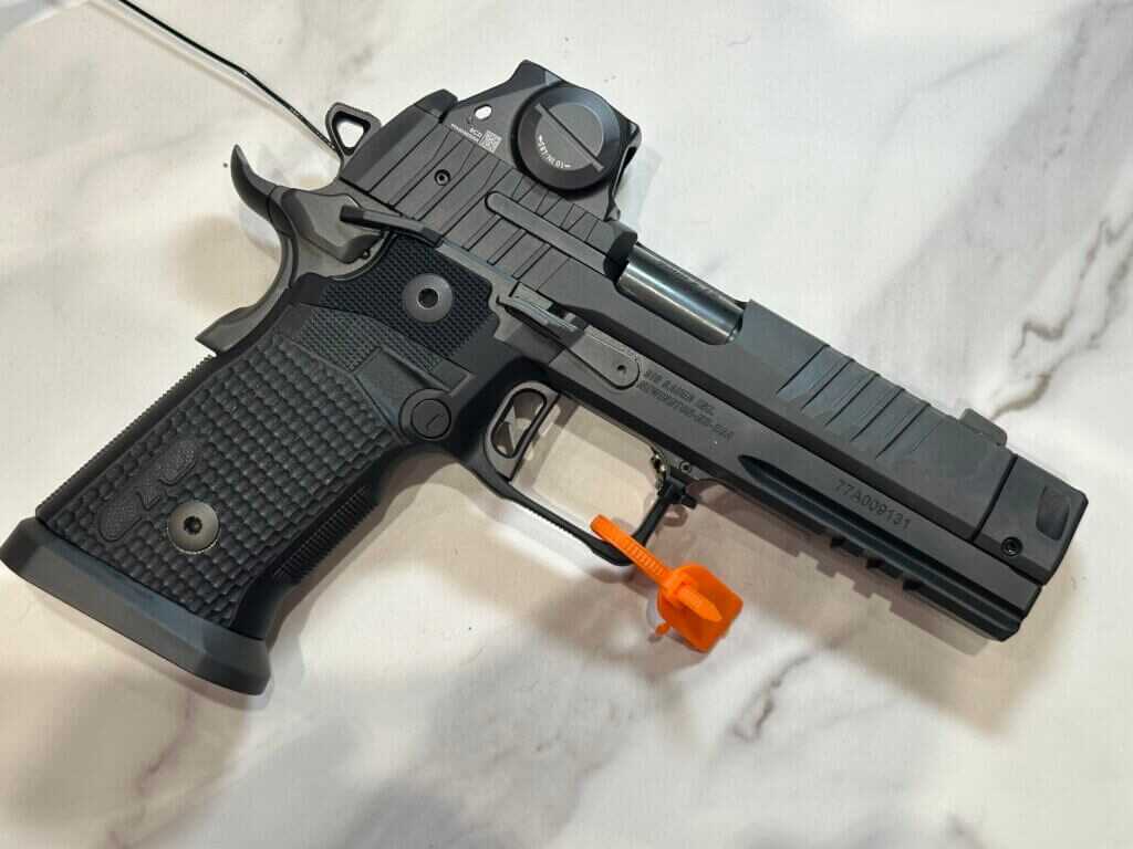 A black handgun rests on a white marble countertop.