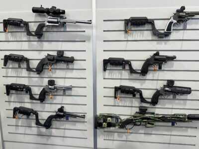 A wall is covered with pistols hanging on hooks. Each has the attachable Bounty Hunter Series stock or brace.