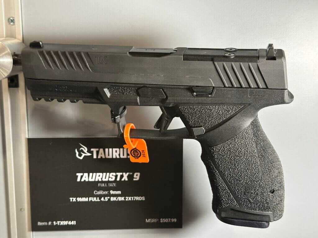 A pistol is pointing from left to right and a placard is shown behind it with details.