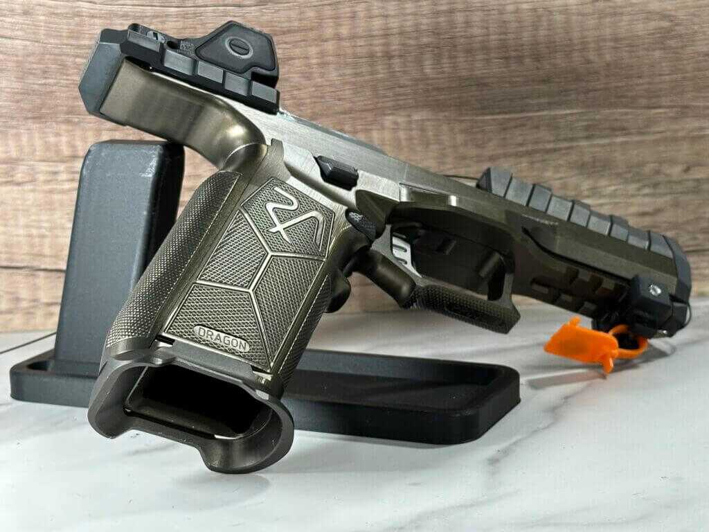 There is a pistol resting on a display stand, pointing away to show the inside of the magazine well.