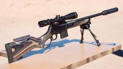 The whole gun on a shooting table at the range, pointing to the right downrange.