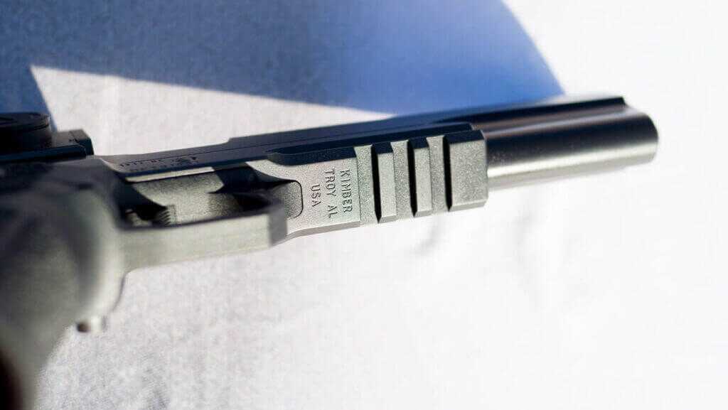 The underside of the barrel in front of the trigger guard is shown, revealing the Picatinny rail.