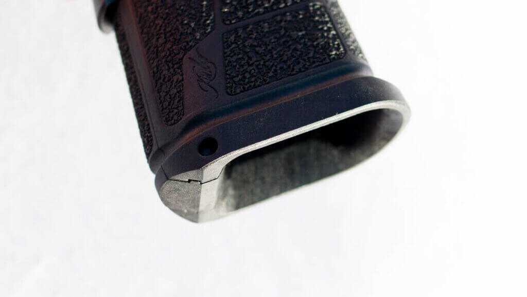 CLose up view of the bottom of the grip showing the flared magwell without a magazine.