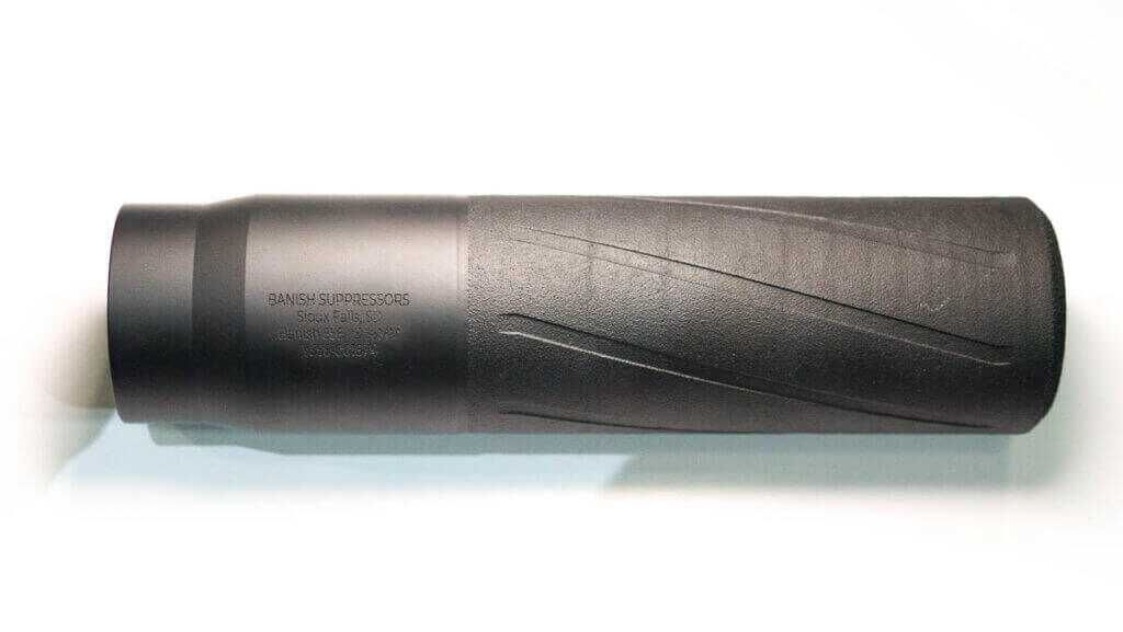 The supressor laying flat on a table pointing right.