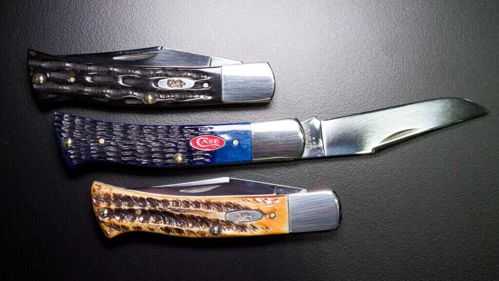 Three knives in various colors with the center one open.