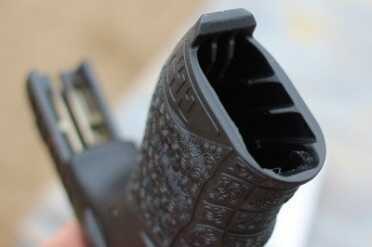 The inside of the mag well has ribs that guide the mag into place. The question is why not have a wider magazine and increase capacity?