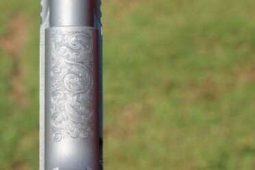 The mainspring housing is engraved. The front strap is not.