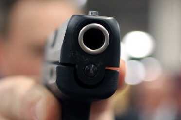 Hard to see in this image, but the barrel is resting in a V shaped cut in the slide which centers it.