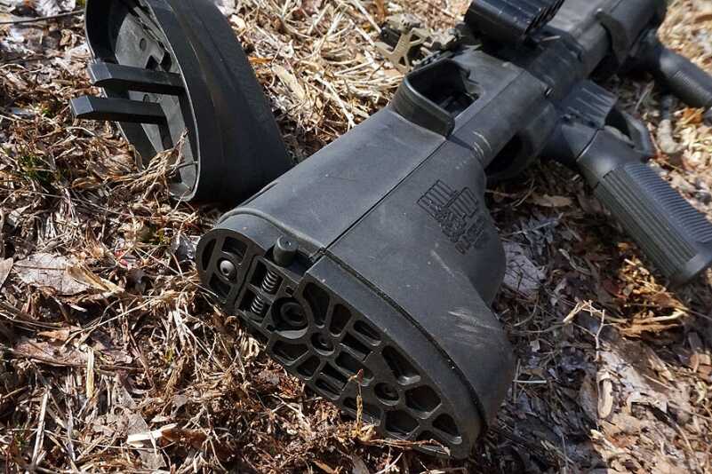 The rear end of the shotgun is secured just behind the thick buttstock.