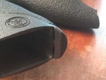 The backstrap removal pin shown in its normal position. To remove, turn 90 degrees and pull it out.