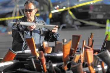 KORWIN: America’s Real Gun Problem -- The Progressive’s Gun Myths A man looks at a weapon at a gun buyback event at the Los Angeles Memorial Sports Arena in December 2012. Police officials say buybacks help drive down gun-related violence, but some experts question how effective these programs are. (Rick Loomis / Los Angeles Times)