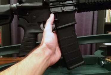 You do not have to remove the rifle from the rest to remove or replace the magazine.