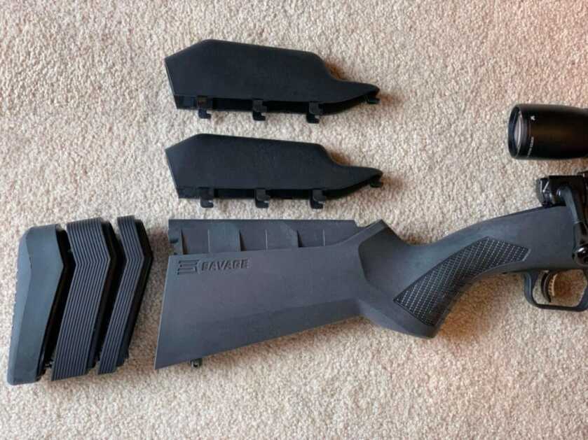 a rifle stock lays on the ground, taken apart.